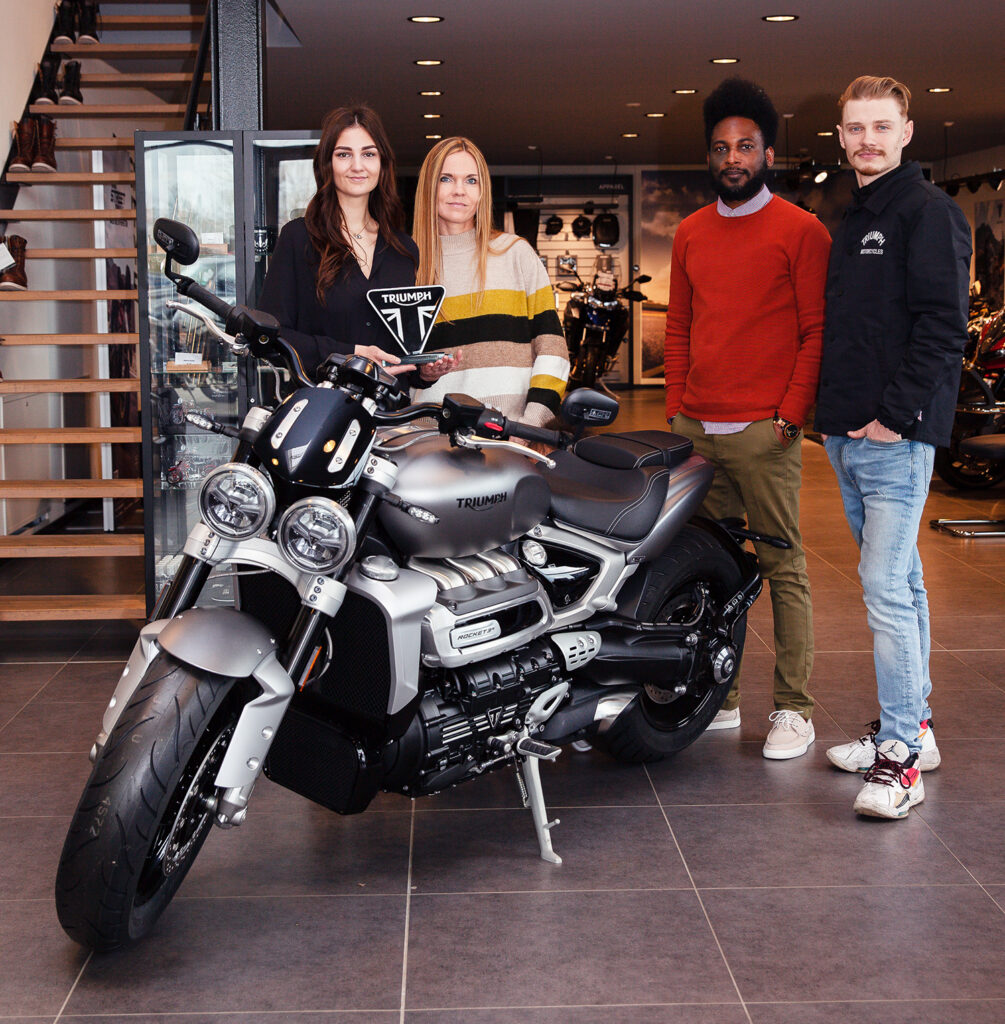 Teamfoto bei Triumph Münster mit einem Triumph-Motorrad